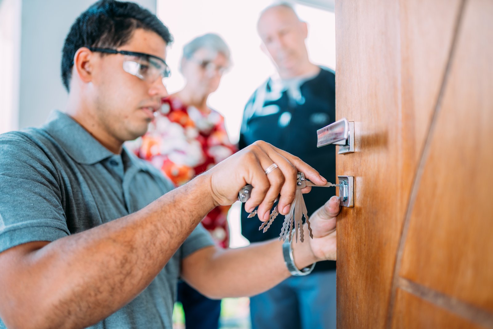 A locksmith speaking with customers at a residential doorway