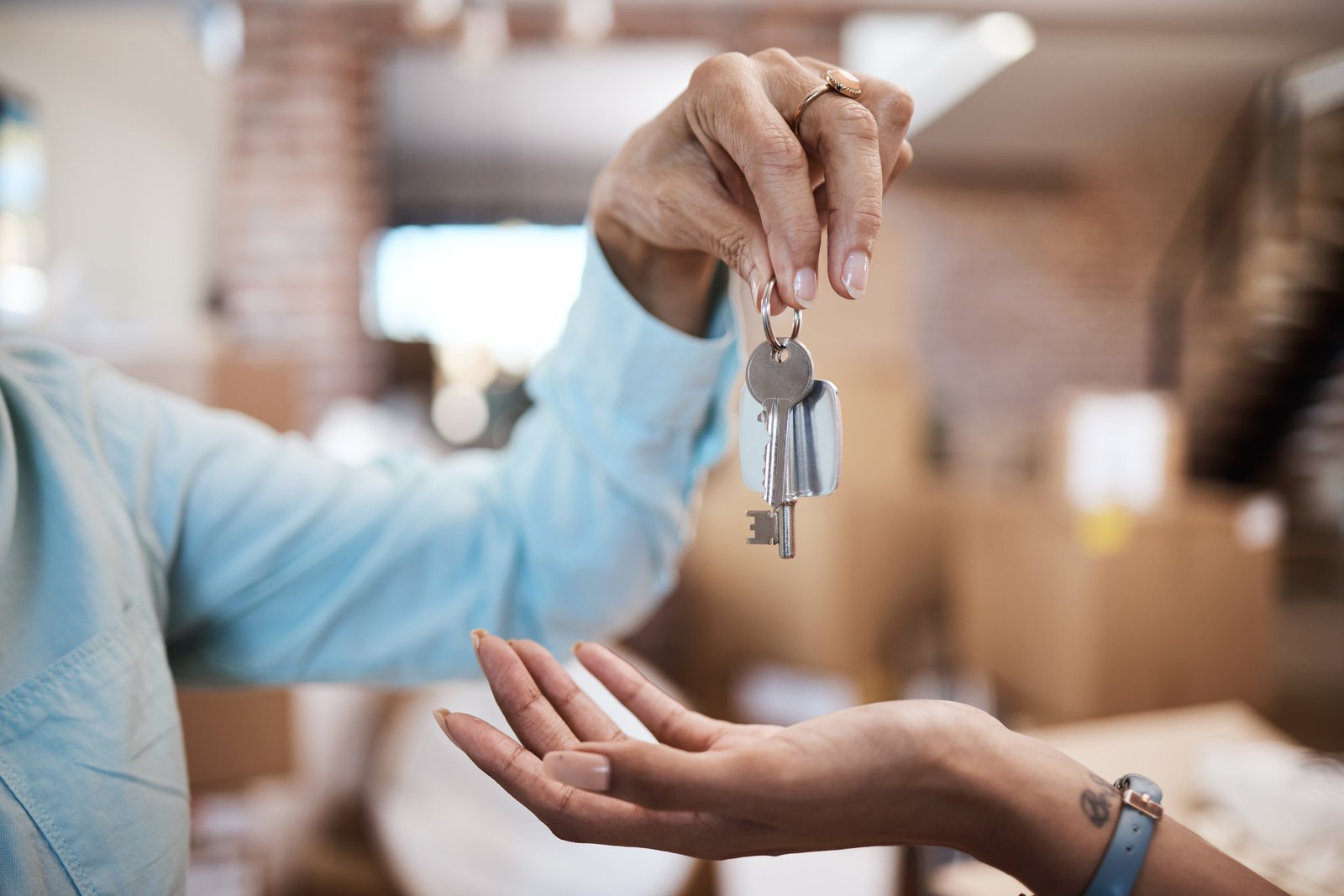 A key handover between two people at a property doorway