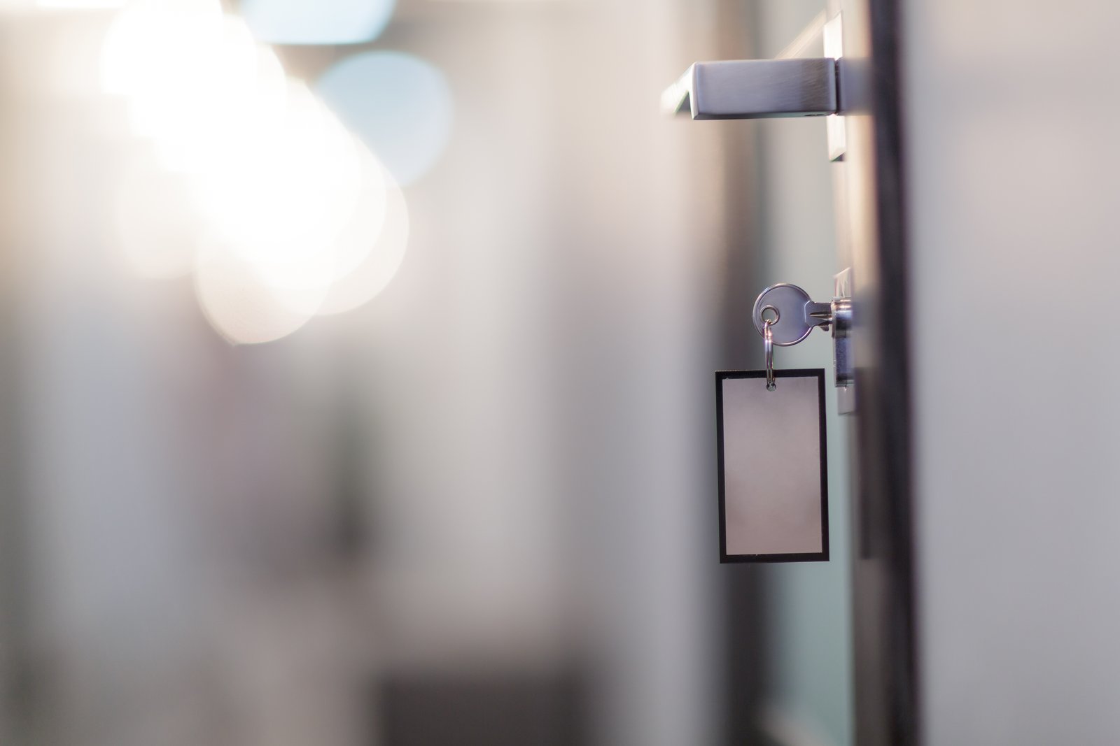 A key with a blank tag resting against a commercial premises door