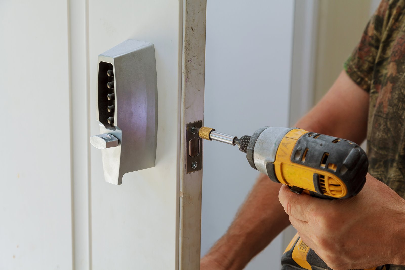 Hands fitting an electronic keypad lock to a glass commercial door