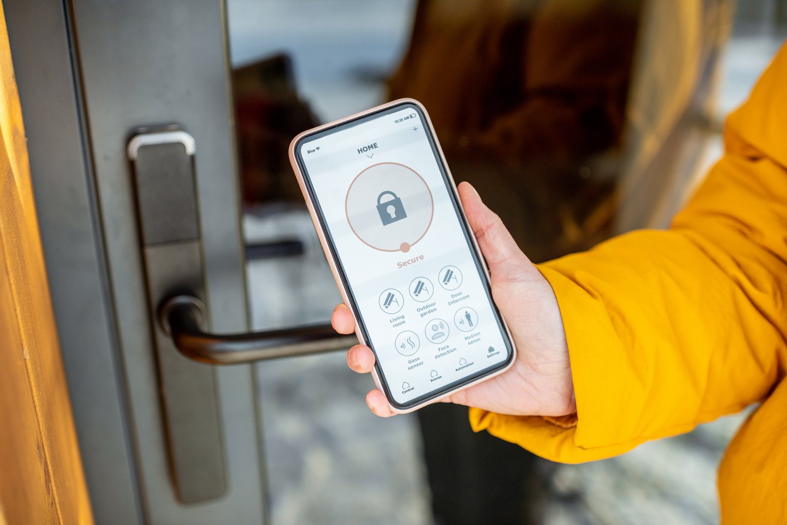 A hand holding a smartphone displaying a smart lock control app beside a door