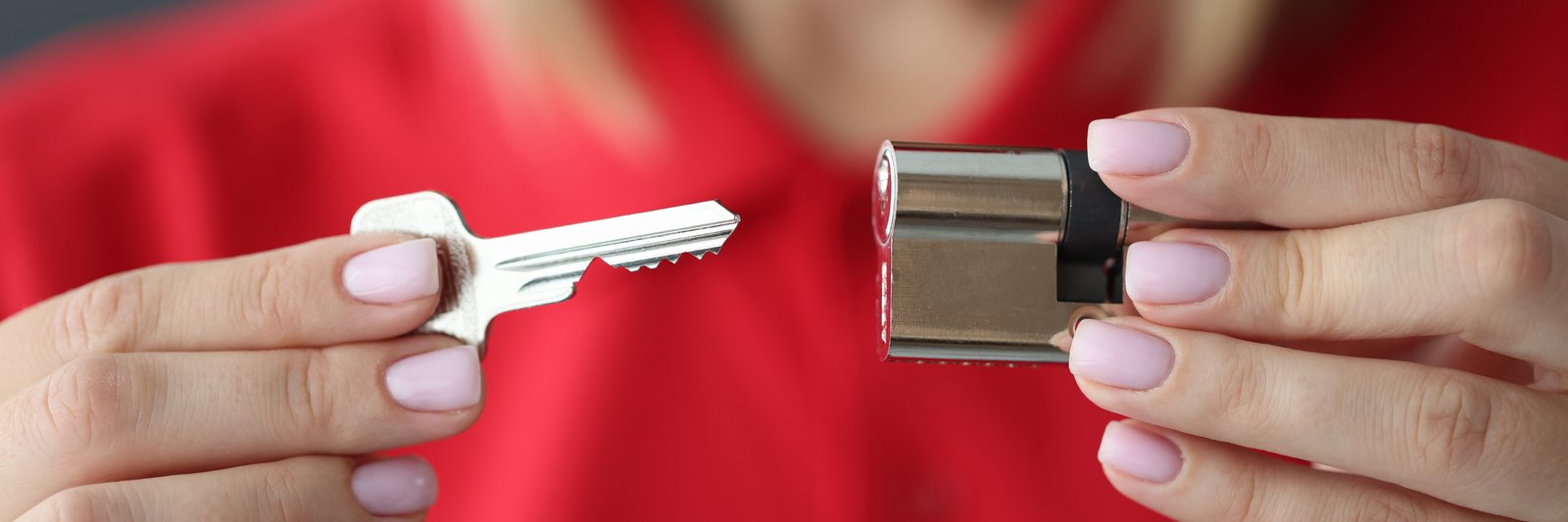 Hands holding a euro cylinder lock barrel and a cut key