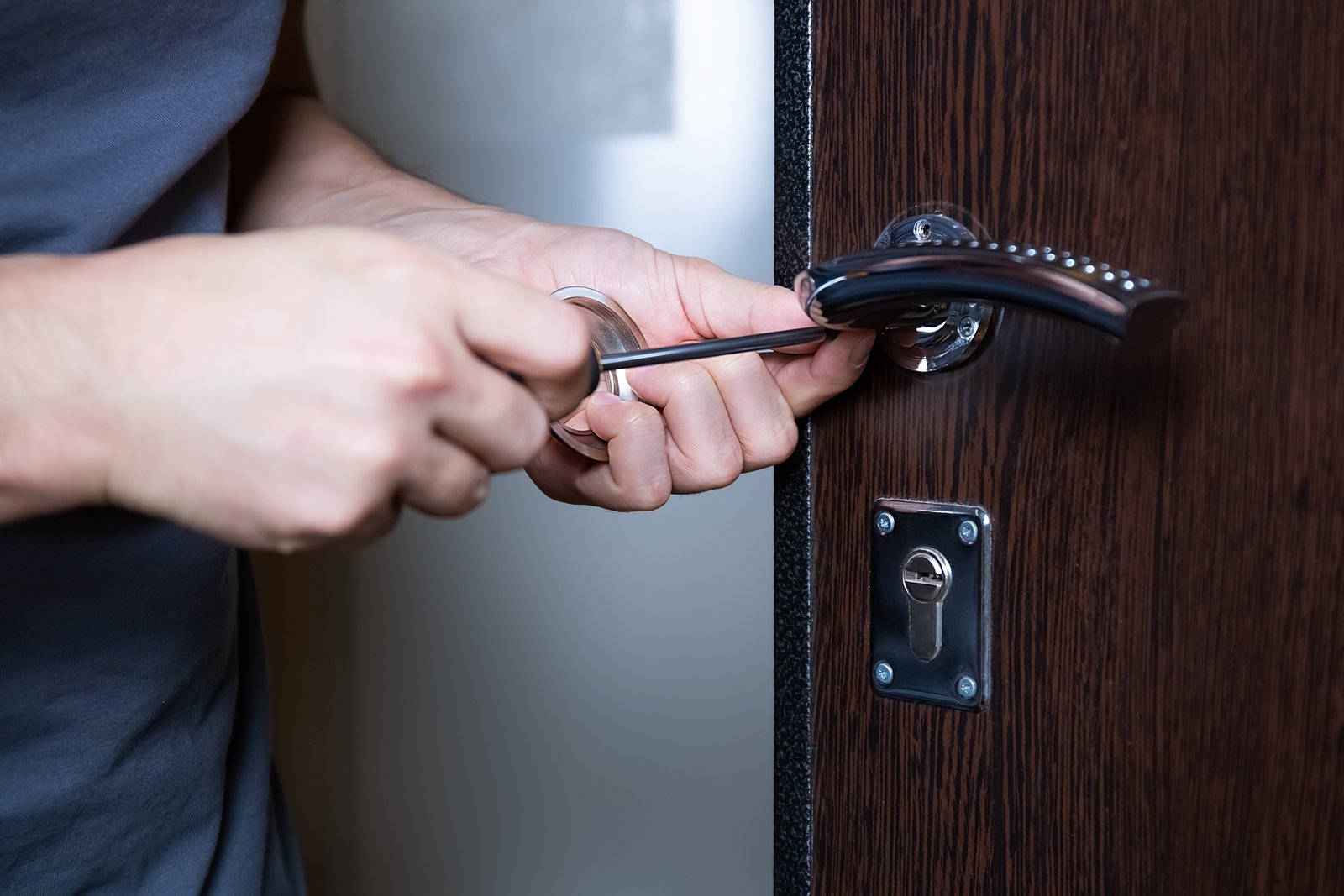A hand adjusting a thumbturn cylinder lock fitted to an exterior door