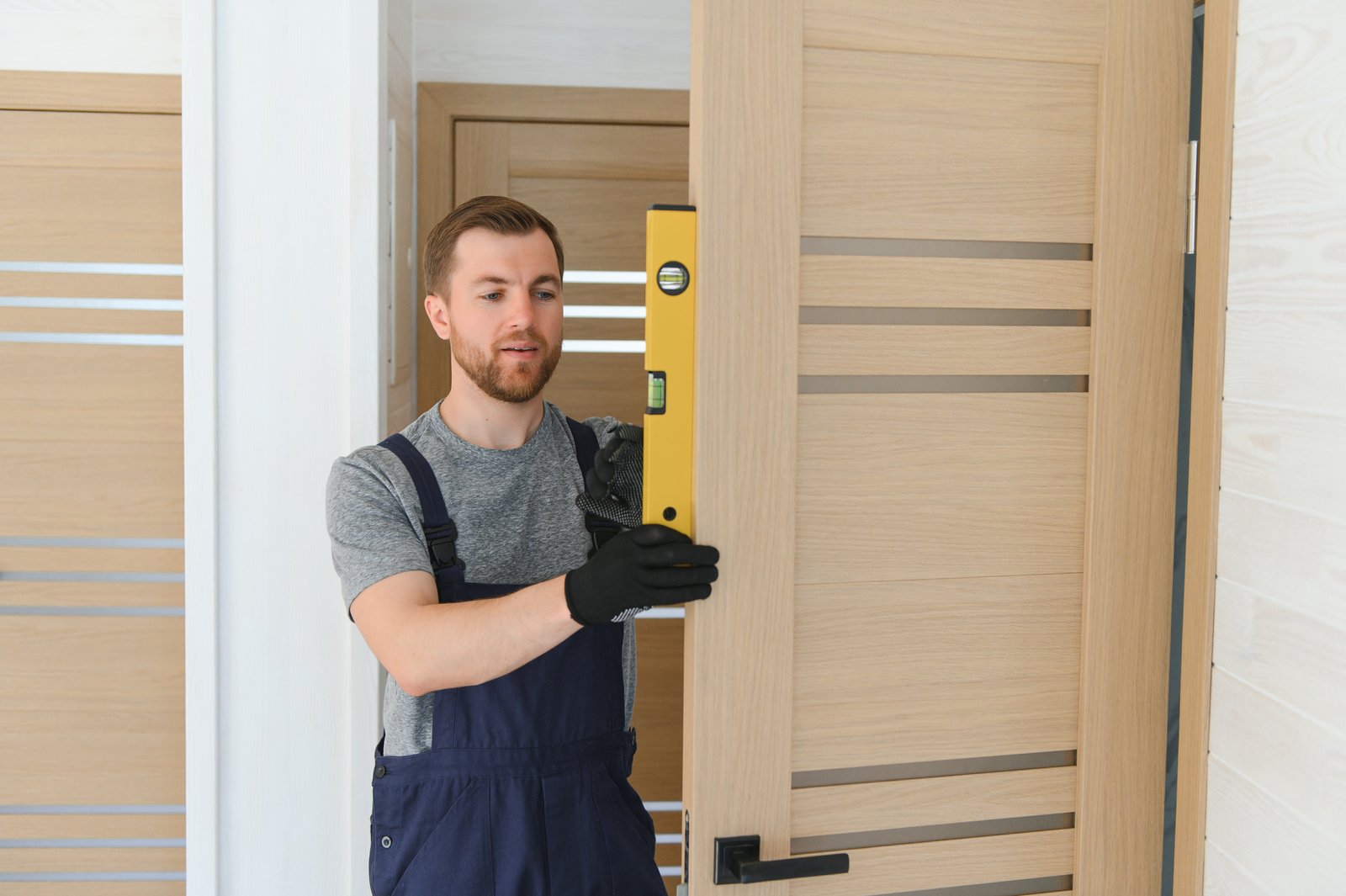 A tradesperson checking a residential door with a spirit level