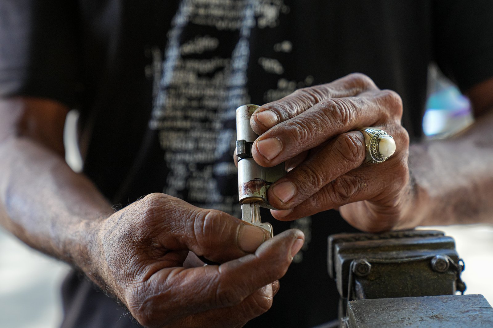 A locksmith testing a key in a euro cylinder lock at a workbench